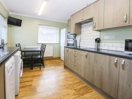 A kitchen with dining table and appliances at Pen Y Garth near Mynytho near Llanbedrog