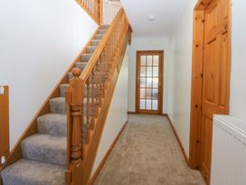 A hallway with a staircase and doors at Pen Y Garth in Mynytho near Llanbedrog