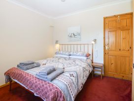 A bedroom with a bed and bedside table at Pen Y Garth in Mynytho near Llanbedrog