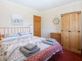 A bedroom with a bed and wardrobe at Pen Y Garth Mynytho near Llanbedrog