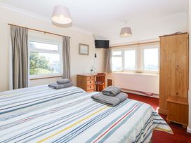 A bedroom with beds and a dresser at Pen Y Garth in Mynytho near Llanbedrog