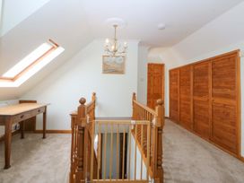 A hallway with a table and staircase at Pen Y Garth Mynytho near Llanbedrog