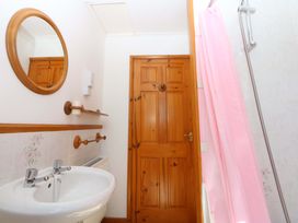 A bathroom with a sink, mirror, and shower at Pen Y Garth, Mynytho near Llanbedrog