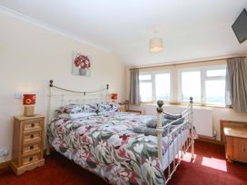 A bedroom with a bed and windows at Pen Y Garth Mynytho near Llanbedrog