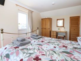 A bedroom with a bed and wooden furniture at Pen Y Garth in Mynytho near Llanbedrog