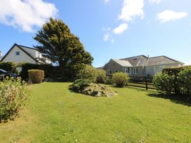 A garden with a house and tree at Pen Y Garth in Mynytho near Llanbedrog