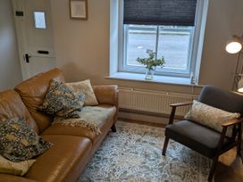 A living room with a sofa and chair at Troopers Cottage in Frome
