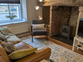 A living room with a sofa, chair, and fireplace at Troopers Cottage in Frome