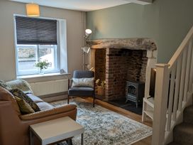 A living room with a sofa and fireplace at Troopers Cottage in Frome