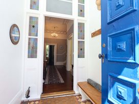A hallway with a blue front door and a bench at Holcombe House in Torquay