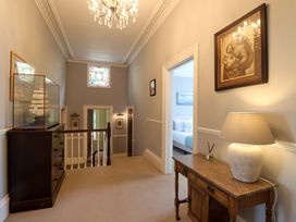 A hallway with a chest of drawers and a lamp at Holcombe House in Torquay
