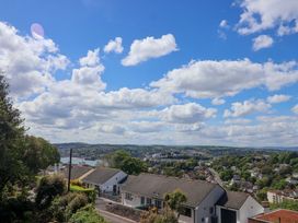 A view of houses and trees under a cloudy sky at Holcombe House in Torquay
