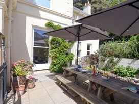 A garden with a picnic table and umbrellas at Holcombe House in Torquay