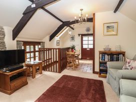 A living room with a television and dining area at The Coach House in Kingston