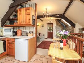 A kitchen with wooden cabinets and appliances at The Coach House in Kingston