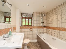 A bathroom with a bathtub, toilet, sink and shower at The Coach House in Kingston