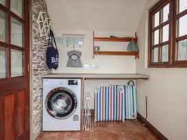 A laundry room with a washing machine and drying racks at The Coach House in Kingston