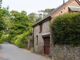 A house on a road surrounded by trees and bushes at The Coach House in Kingston