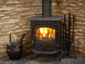 A wood stove with fire and ash bucket at The Coach House in Kingston