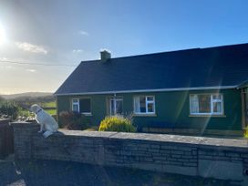 A house with a dog sitting on the wall at Sea View Hideaway, Lahinch, County Clare
