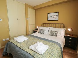 A bedroom with a bed and wardrobe at 56C South Snowdon Wharf in Porthmadog