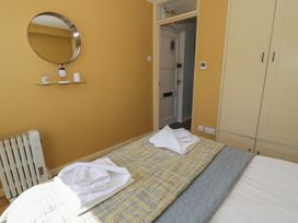 A bedroom with a bed and mirror at 56C South Snowdon Wharf in Porthmadog