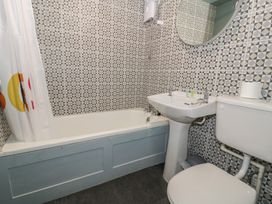 A bathroom with a bathtub, sink, and toilet at 56C South Snowdon Wharf in Porthmadog