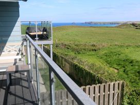 A balcony with a table and view of the sea at Sandpiper Perranporth