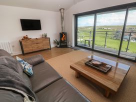 A living room with a sofa and a fireplace at Sandpiper in Perranporth
