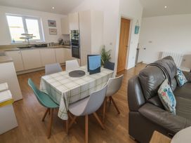A kitchen with a dining table and chairs at Sandpiper in Perranporth