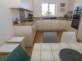 A kitchen with cabinets and appliances at Sandpiper in Perranporth