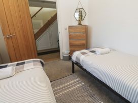 A bedroom with twin beds and a chest of drawers at Sandpiper in Perranporth