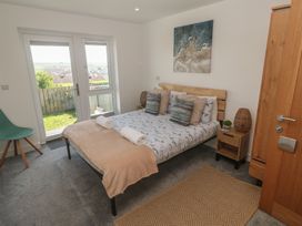 A bedroom with a bed and windows at Sandpiper in Perranporth