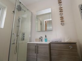 A bathroom with a shower and sink at Sandpiper in Perranporth