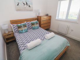 A bedroom with a bed and drawers at Sandpiper in Perranporth