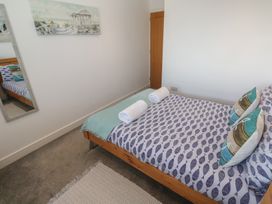 A bedroom with a bed and towels at Sandpiper in Perranporth