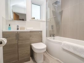A bathroom with a bathtub and toilet at Sandpiper in Perranporth