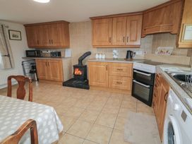 A kitchen with wooden cabinets and appliances at Shaws Hill Farmhouse in Kells, County Antrim