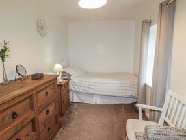 A bedroom with a bed and dresser at Shaws Hill Farmhouse, Kells, County Antrim