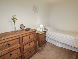A bedroom with a bed and dresser at Shaws Hill Farmhouse, Kells, County Antrim