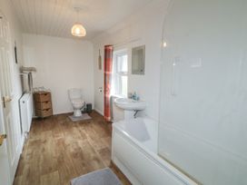 A bathroom with a bath tub, toilet, and sink at Shaws Hill Farmhouse, Kells, County Antrim
