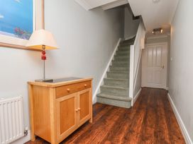 A hallway with a lamp and console table at Tides Reach in Whitby