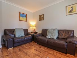 A living room with two sofas and a lamp at Tides Reach in Whitby