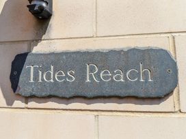 A sign on a wall that reads Tides Reach at Tides Reach in Whitby