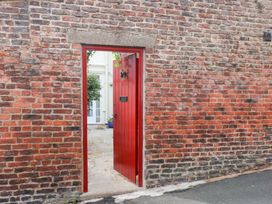 A red door opening to a courtyard at 20A St Hilda's in Whitby
