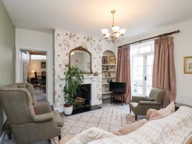 A living room with a sofa, armchair, and fireplace at 20A St Hilda's in Whitby