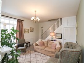 A living room with a sofa, chairs, and a lamp at 20A St Hilda's in Whitby