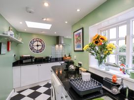 A kitchen with clock and flowers at 20A St Hilda's Whitby