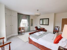 A bedroom with a bed, armchair, and window at 20A St Hilda's in Whitby