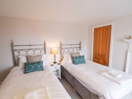 A bedroom with two beds and a nightstand at 20A St Hilda's in Whitby